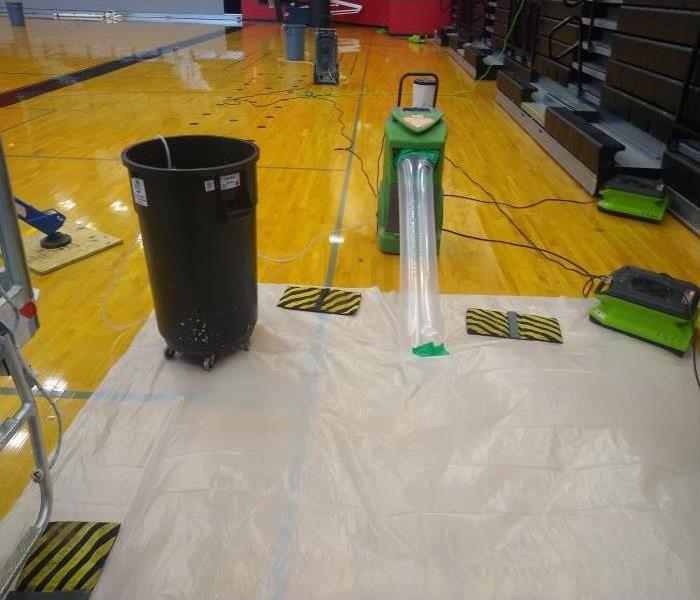 basketball court after water removal and setting up professional drying equipment on the court flooring