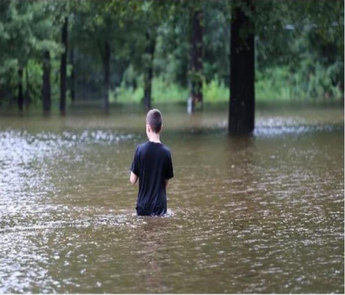 Person waist deep in the flood water