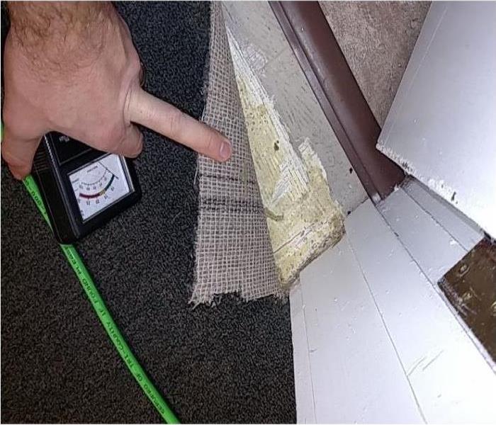 SERVPRO technician checking to see if carpeting is damaged.