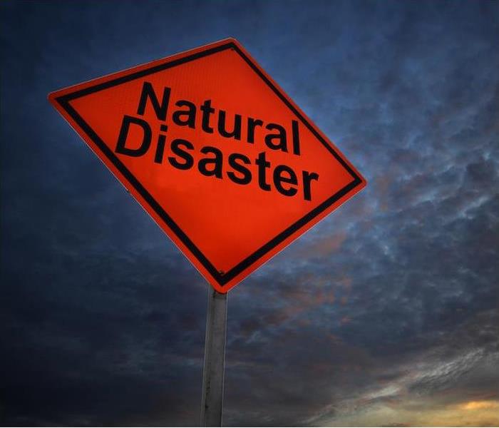 “large red diamond shape sign with Natural Disaster written in large black print"