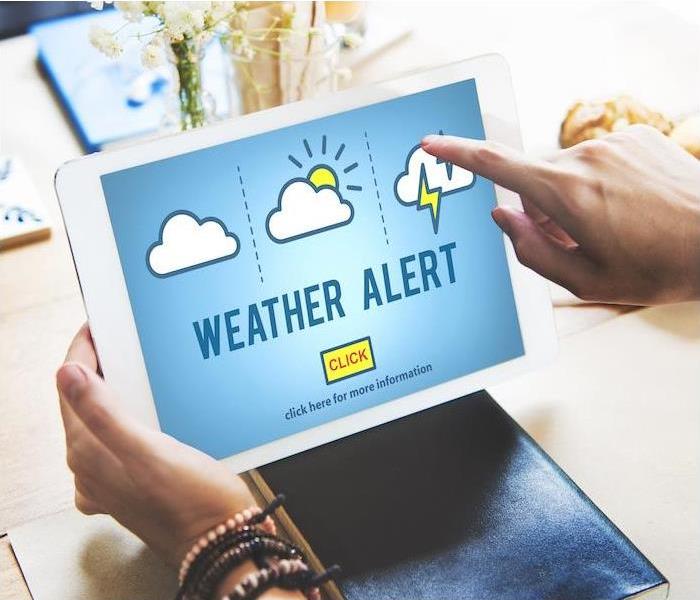 person on a tablet using weather alert app 